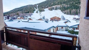 Eine verschneite Bergstadt mit Gebäuden und einer Seilbahn.