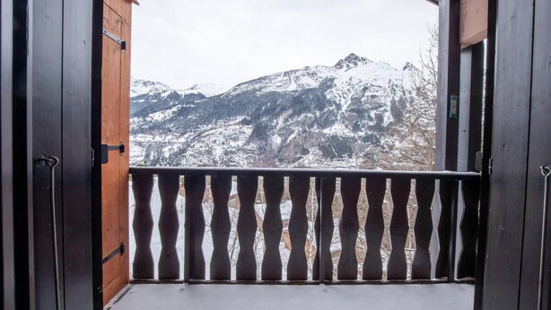 A balcony with a view of snow-covered mountains.