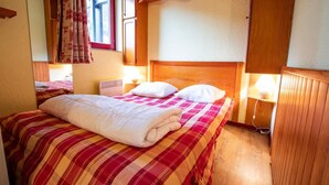 Een gezellige slaapkamer met een groot bed, houten hoofdbord en een raam met gordijnen.
