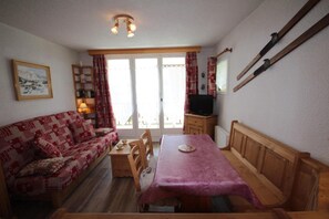 Un salon confortable avec un canapé, une table à manger et un téléviseur.