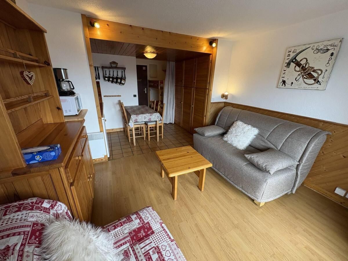 A cozy living room with a grey sofa, wooden coffee table, and a wooden cabinet.