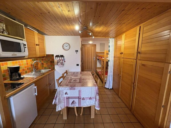A compact kitchen with a microwave, sink, and a table set for dining.