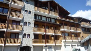 Un hotel de varios pisos con balcones de madera y fachada de piedra.
