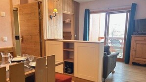 A compact living space with a dining area, a sofa, and a kitchenette. - 100m from ski slopes, 3rd floor, view ski slopes, swimming pool, sauna, balcony, tv, ski locker (Risoul)