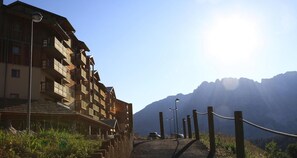 A wooden building with multiple balconies, a clear sky, and mountains in the background. - 50m from ski slopes, 4th floor, view mountain, balcony, tv, 41m², Superdévoluy (Le Dévoluy)