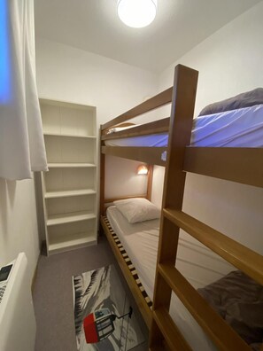 A bunk bed with a headboard, a shelf unit, and a wall-mounted light fixture. - 50m from ski slopes, 4th floor, view mountain, balcony, tv, 41m², Superdévoluy (Le Dévoluy)