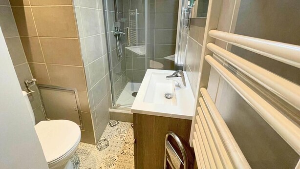 Un baño con ducha acristalada, un lavabo blanco y un inodoro.