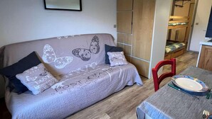 A cozy room with a sofa, a dining table, and a kitchen area. - Ground floor, view ski slopes, balcony, tv, 24m², Le Grand Bornand (Le Grand-Bornand)