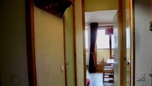 Un pasillo que conduce a un comedor con una mesa y sillas.