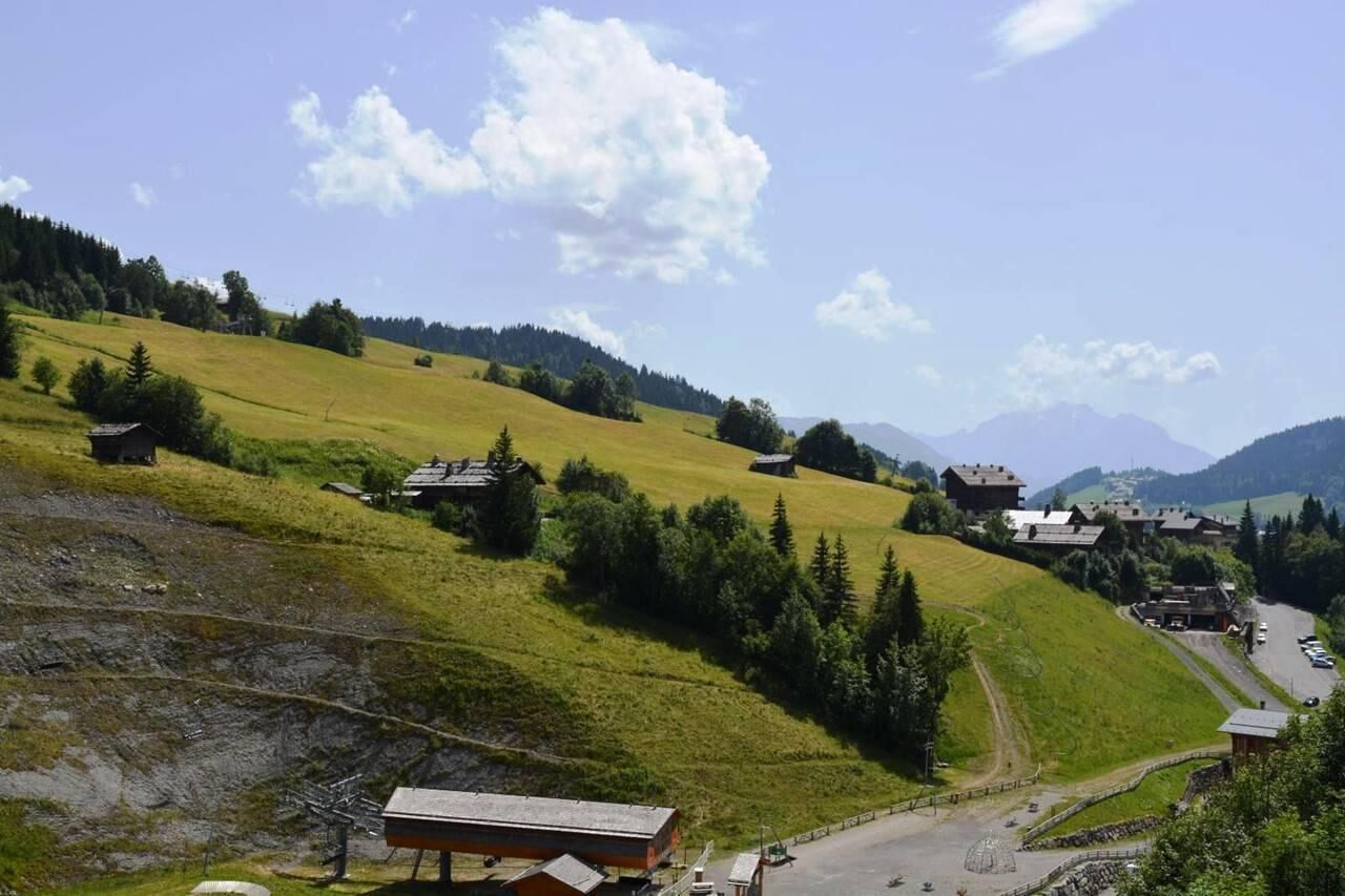 A rural landscape with houses on a hillside, a road, and a clear sky.