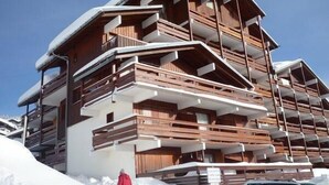 A multi-story wooden building with balconies, surrounded by snow. - 150m from ski slopes, 2nd floor, view ski slopes, balcony, tv, ski locker, 24m², Les Saisies (Les Saisies)