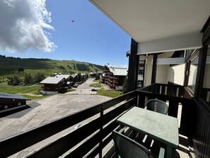 A balcony with a view of a village, including buildings and a road.