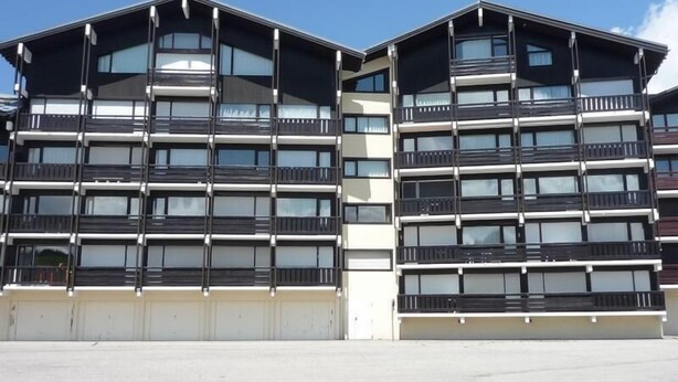 A modern multi-story building with a flat roof, large windows, and balconies. - 200m from ski slopes, 4th floor, view ski slopes, balcony, tv, ski locker, 18m², Les Saisies (Les Saisies)