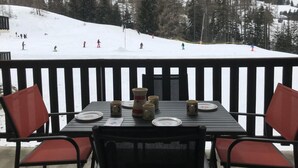 Ein Esstisch mit Blick auf einen verschneiten Berghang.