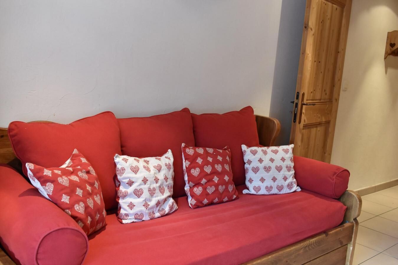 A red sofa with heart-patterned pillows.