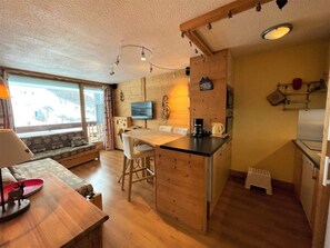 A compact living space with a kitchenette, a dining area, and a sofa. - 10m from ski slopes, 3rd floor, balcony, tv, 36m², Les Menuires (Les Menuires)