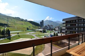 A balcony with a view of a ski resort, including a ski lift, buildings, and mountains. - 10m from ski slopes, 3rd floor, balcony, tv, 36m², Les Menuires (Les Menuires)