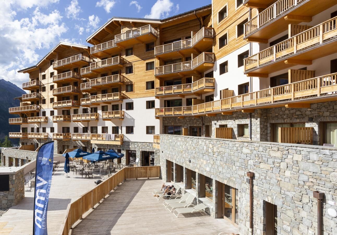 Ein mehrstöckiges Hotel mit hölzernen Balkonen und einer Stein-Fassade.