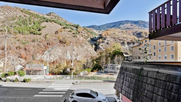 Un aparcamiento con un coche blanco, un paso de peatones y un edificio con un letrero que dice "Sergio Hotel".