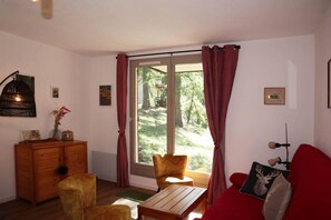 Relax in this inviting living room with a large window, wooden cabinet, and comfortable sofa.
