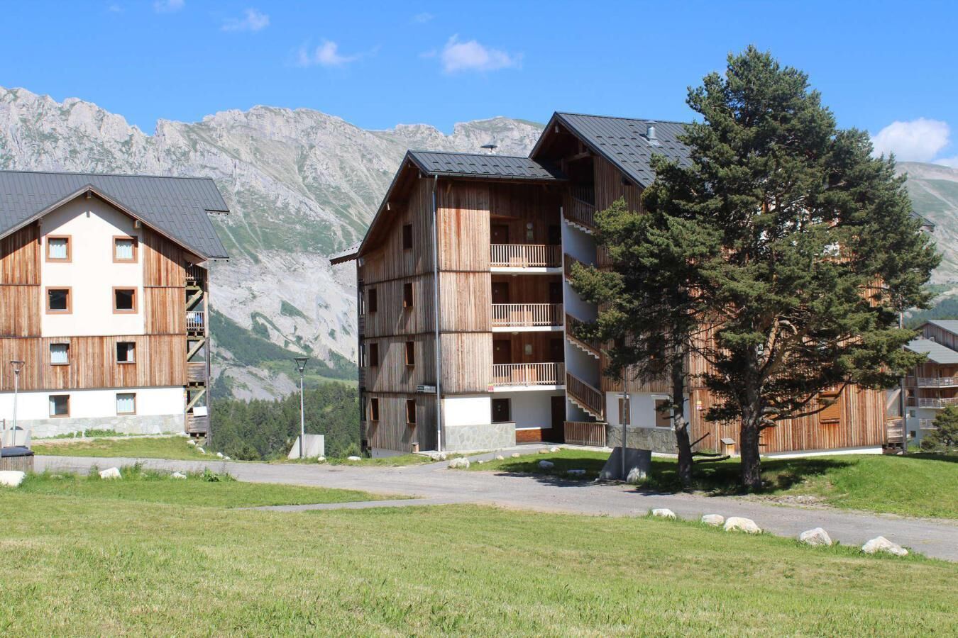 A wooden building with multiple balconies and a mountain backdrop.