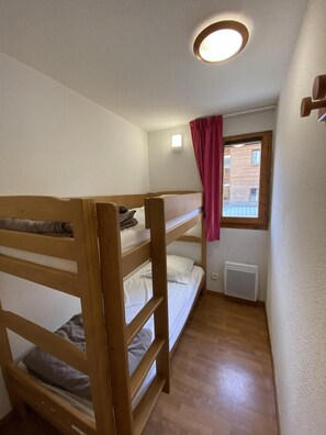 A bunk bed room with a window, a radiator, and a ceiling light. - 1st floor, view mountain, balcony, tv, 32m², La Joue du Loup (Le Dévoluy)