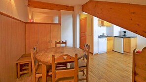 Cozy apartment with a dining table, kitchenette, and additional living space.