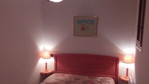 A bedroom with a bed, two bedside lamps, a hanging light fixture, a framed picture on the wall, and a window on the right. - 200m from ski slopes, 3rd floor, view mountain, balcony, tv, ski locker, 36m², Champagny-en-Vanoise (Champagny-en-Vanoise)