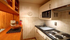 A compact kitchen with a microwave, stove, and sink. - 50m from ski slopes, 1st floor, terrace, tv, 35m², Champagny-en-Vanoise (Champagny-en-Vanoise)