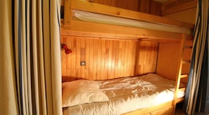 A bunk bed with a wooden headboard and a ladder on the right. - 50m from ski slopes, 1st floor, terrace, tv, 35m², Champagny-en-Vanoise (Champagny-en-Vanoise)