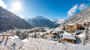 A snow-covered mountain village with traditional wooden buildings, a prominent mountain peak in the background, and a clear blue sky. - 50m from ski slopes, 2nd floor, balcony, tv, 21m², Champagny-en-Vanoise (Champagny-en-Vanoise)