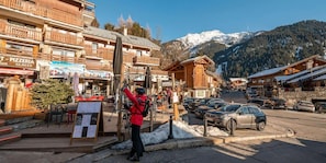 A ski resort with wooden buildings, a ski lift, and a mountain backdrop. - Resort center, 2nd floor, balcony, tv, 21m², Champagny-en-Vanoise (Champagny-en-Vanoise)