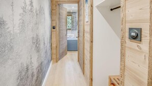 A hallway with wooden walls and a wooden door with a handle. - Resort center, 4th floor, balcony, tv, 29m², Champagny-en-Vanoise (Champagny-en-Vanoise)