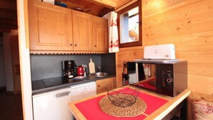 A compact kitchen with wooden cabinets, a coffee maker, a microwave, and a dishwasher. - 300m from ski slopes, 2nd floor, view panoramic, balcony, tv, ski locker, 45m², Les Saisies (Les Saisies)