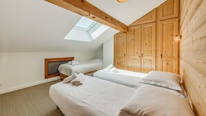 A bedroom with two beds, a skylight, wooden wardrobe, and a ceiling light fixture. - 200m from ski slopes, 3rd floor, balcony, fireplace or stove, tv, ski locker, 54m² (Champagny-en-Vanoise)