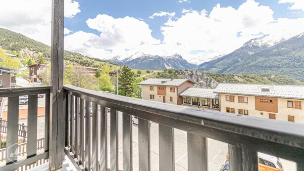 A balcony with a mountain view, featuring buildings and a road in the foreground. - 150m from resort center, 2nd floor, balcony, tv, ski locker, 29m², Aussois (Aussois)