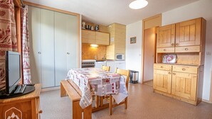 A compact kitchen with wooden cabinets, a microwave, and a stove. - 10m from ski slopes, 1st floor, balcony, tv, 26m², Aussois (Aussois)