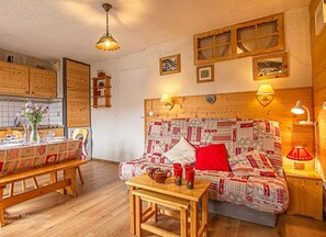 A cozy room with a wooden headboard, a dining table with a checkered tablecloth, and a bench. - 150m from ski slopes, 1st floor, balcony, tv, ski locker, 27m², Aussois (Aussois)