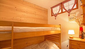 A bunk bed room with wooden walls and a bedside table with a lamp. - 150m from ski slopes, 1st floor, balcony, tv, ski locker, 27m², Aussois (Aussois)