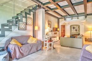 Un intérieur moderne avec un escalier, un canapé, une table à manger et une cheminée.