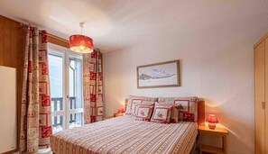 A bedroom with a bed, a nightstand, a lamp, a window with curtains, and a painting on the wall. - 300m from ski slopes, 2nd floor, balcony, tv, ski locker, 41m², Aussois (Aussois)