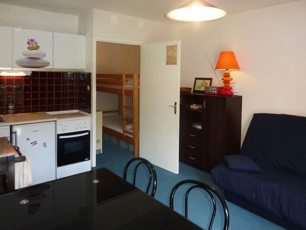 Ein gemütlicher Wohnbereich mit Küchenzeile, Esstisch, Sofa und Lampe.