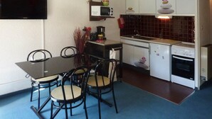 A compact kitchen with a dining table, chairs, a microwave, a stove, and a sink. - 300m from ski slopes, 2nd floor, view forest, balcony, tv, ski locker, 24m², Les Orres (Les Orres)