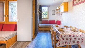 A cozy room with a bed, a bench, a dining table set for four, and a window with a view of mountains. - Ski-in/ski-out & foot of the slopes, 2nd floor, view ski slopes, terrace, tv, 24m² (Bellentre)