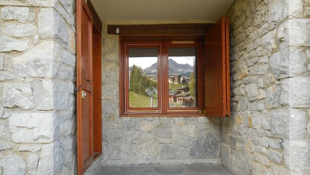 A stone-walled room with a window and wooden shutters. - Ski-in/ski-out & foot of the slopes, 2nd floor, view ski slopes, terrace, tv, 24m² (Bellentre)