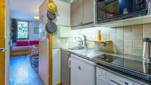A compact kitchen with a microwave, dishwasher, and a small sink. There is a window with a view of greenery outside. - Ski-in/ski-out & foot of the slopes, 2nd floor, view ski slopes, terrace, tv, 24m² (Bellentre)