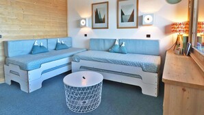 Ein kleiner Raum mit zwei hellblauen Sofas, einem kleinen runden Tisch und einer Holzvertäfelung.
