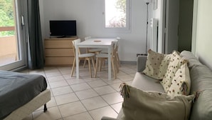 A room with a bed, a sofa, a dining table with chairs, a TV, and a window. - 150m from resort center, 1st floor, balcony, tv, 26m², Brides Les Bains (Brides-les-Bains)