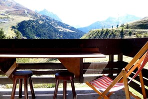 A wooden bench and table with a view of a mountainous landscape. - 10m from ski slopes, 1st floor, view ski slopes, balcony, 40m², Méribel-Mottaret (Méribel - Les Allues)