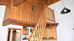 A wooden loft bedroom with a wooden staircase and a hanging light fixture. - 1st floor, terrace, tv, ski locker, 61m², Pralognan-la-Vanoise (Pralognan-la-Vanoise)